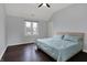 Cozy bedroom features a ceiling fan, blue bedding, and a window with natural light at 12535 Glendurgan Dr, Carmel, IN 46032