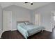 Bedroom with hardwood floors, blue bedding, ceiling fan, and two entry doors at 12535 Glendurgan Dr, Carmel, IN 46032