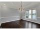 Dining area featuring hardwood floors, a chandelier, and large windows at 12535 Glendurgan Dr, Carmel, IN 46032
