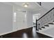 A bright foyer featuring dark hardwood floors, white trim, and a staircase at 12535 Glendurgan Dr, Carmel, IN 46032
