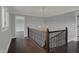 Upstairs hallway with beautiful dark wood railing and hardwood floors at 12535 Glendurgan Dr, Carmel, IN 46032