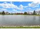 Scenic view of a tranquil pond surrounded by well-manicured lawns and trees at 12535 Glendurgan Dr, Carmel, IN 46032