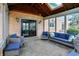 Enclosed sunroom with brick wall, skylights, tile flooring, and wicker furniture at 12535 Glendurgan Dr, Carmel, IN 46032