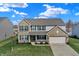 Two-story home featuring a brick and vinyl facade, attached two-car garage, and a charming covered front porch at 1279 Windswept Dr, Greenwood, IN 46143