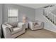 Comfortable living room with two armchairs, neutral carpet, and a stairway to the upper level at 1279 Windswept Dr, Greenwood, IN 46143