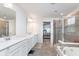 Bright bathroom featuring double vanity, soaking tub, and glass shower enclosure at 12988 Fernie Cir, Fishers, IN 46037