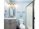 Bright bathroom featuring light blue walls, vanity, black accents, glass shower, and modern lighting fixtures at 12988 Fernie Cir, Fishers, IN 46037