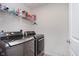 Modern laundry room equipped with gray front-load washer and dryer at 12988 Fernie Cir, Fishers, IN 46037