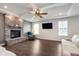 Comfortable living room with stone fireplace, ceiling fan and large windows at 12988 Fernie Cir, Fishers, IN 46037
