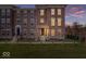 Brick townhome with a manicured lawn and covered entry, showcasing a blend of classic architecture and modern living at 13833 Tender Dr, Carmel, IN 46032