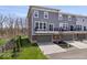 Three-story townhome featuring gray siding, brick and a two car garage at 13833 Tender Dr, Carmel, IN 46032