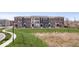 A long row of three-story townhomes set against a grass hillside at 13833 Tender Dr, Carmel, IN 46032