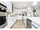 Bright kitchen with stainless steel appliances, white cabinets, light wood floors and herringbone backsplash at 14477 Stairbridge Pl, Carmel, IN 46032