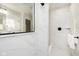 Luxurious walk-in shower with white marble tile, black fixtures, and convenient shelf at 14477 Stairbridge Pl, Carmel, IN 46032