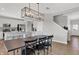 Open-concept dining area with a modern chandelier, dining table, kitchen with stainless appliances, and staircase at 15206 Swallow Falls Way, Fishers, IN 46037