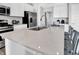 Well-appointed kitchen featuring a spacious island, stainless steel appliances, seating and durable, easy-to-clean quartz countertops at 15206 Swallow Falls Way, Fishers, IN 46037