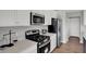 The modern kitchen is equipped with stainless steel appliances, quartz countertops and white cabinets for a sleek look and feel at 15206 Swallow Falls Way, Fishers, IN 46037
