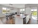 Bright open kitchen featuring an island, dining area, wood floors and plenty of natural light from the surrounding windows at 15206 Swallow Falls Way, Fishers, IN 46037