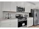 A well-equipped kitchen with stainless steel appliances, white cabinets, and ample counter space for cooking and meal preparation at 15206 Swallow Falls Way, Fishers, IN 46037