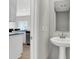 Elegant powder room showcasing a pedestal sink, sleek mirror, and nearby kitchen at 15214 Swallow Falls Way, Fishers, IN 46037