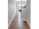 Hallway leads to dining area, featuring hardwood floors and neutral paint at 15214 Swallow Falls Way, Fishers, IN 46037