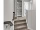 Hallway with carpeted stairs and a view of a linen closet, leading into the kitchen at 15214 Swallow Falls Way, Fishers, IN 46037