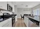 Well-equipped kitchen features stainless steel appliances, black countertops, and a stylish dining area at 15214 Swallow Falls Way, Fishers, IN 46037