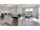 Open concept kitchen with island seating flows seamlessly into the comfortable living room space at 15214 Swallow Falls Way, Fishers, IN 46037