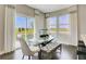 Elegant dining space with a glass-top table, seating bench, and view of the outdoor scenery at 15294 Swallow Falls Way, Fishers, IN 46037