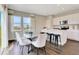 Bright dining area with a sleek glass table, white chairs, and scenic outdoor views through large windows at 15294 Swallow Falls Way, Fishers, IN 46037