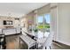 Modern dining room adjacent to the kitchen with a glass table, chic chairs, and backyard views at 15294 Swallow Falls Way, Fishers, IN 46037