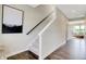 Hallway with wood floors and leading to the stairs, with sightlines to the living room at 15294 Swallow Falls Way, Fishers, IN 46037