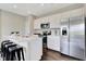 Bright kitchen features white cabinetry, stainless steel appliances, an island with barstool seating, and dark wood floors at 15294 Swallow Falls Way, Fishers, IN 46037