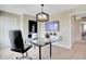 A fully furnished home office offers a glass desk, modern decor, and a wall-mounted television for video conferencing at 15294 Swallow Falls Way, Fishers, IN 46037