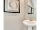 Clean and simple powder room with a white pedestal sink, neutral walls, and decorative art at 15294 Swallow Falls Way, Fishers, IN 46037