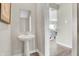 Stylish powder room featuring a pedestal sink, neutral color palette, and easy access to the living area at 15294 Swallow Falls Way, Fishers, IN 46037