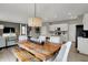 Modern dining area adjacent to the kitchen with a farmhouse dining table and pendant lighting at 15310 Swallow Falls Way, Fishers, IN 46037