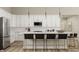Bright kitchen with white cabinets, stainless steel appliances, and a large island with seating at 15384 Cardonia Rd, Fishers, IN 46037