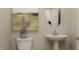 Elegant powder room with pedestal sink, oval mirror, and neutral wall art at 15384 Cardonia Rd, Fishers, IN 46037