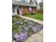 Landscaped front yard featuring vibrant purple flowers lining the walkway to the brick home, offering curb appeal at 1657 Park Terrace Ct, Indianapolis, IN 46229