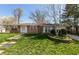 Classic brick ranch-style home featuring a well-maintained lawn, brick planter, and a walkway to the entrance at 1665 South Dr, Columbus, IN 47203