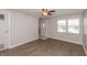 Bright living room with wood-look flooring, neutral walls, a ceiling fan, and a view of the front yard at 1665 South Dr, Columbus, IN 47203