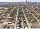 An aerial view showcases modern townhomes nestled in a vibrant neighborhood with the city skyline in the distance at 1811 Livery Way, Indianapolis, IN 46202