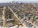 An aerial view showcases modern townhomes nestled in a vibrant neighborhood with the city skyline in the distance at 1811 Livery Way, Indianapolis, IN 46202