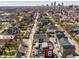 An aerial view showcases modern townhomes nestled in a vibrant neighborhood with the city skyline in the distance at 1811 Livery Way, Indianapolis, IN 46202