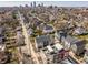 An aerial view showcases modern townhomes nestled in a vibrant neighborhood with the city skyline in the distance at 1811 Livery Way, Indianapolis, IN 46202