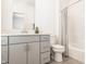 Bathroom with modern vanity and storage, shower with curtain, toilet, and updated lighting at 1811 Livery Way, Indianapolis, IN 46202