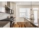 Bright kitchen showcasing modern appliances, gray cabinets, and wood flooring at 1811 Livery Way, Indianapolis, IN 46202