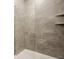 Modern shower featuring large gray tiles, glass enclosure, and built-in shelving for a spa-like experience at 1811 Livery Way, Indianapolis, IN 46202