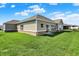 Tan siding, brick foundation and well-maintained lawn highlight this home's backyard at 1896 Woodland Parks Dr, Columbus, IN 47201